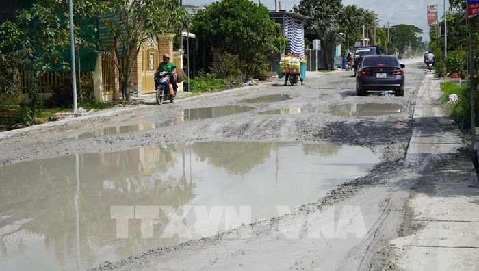 Sau cơn mưa, hố to đọng nước trên Quốc lộ 30 (đoạn qua ấp Gò Da) trở thành “cái bẫy” đối với người đi đường, nhất là vào ban đêm. Ảnh: Nhựt An - TTXVN