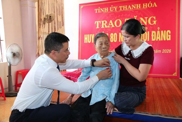 Phó Bí thư Thường trực Tỉnh ủy Nguyễn Hồng Phong gắn Huy hiệu 80 năm tuổi Đảng cho đảng viên Phạm Thị Khang.