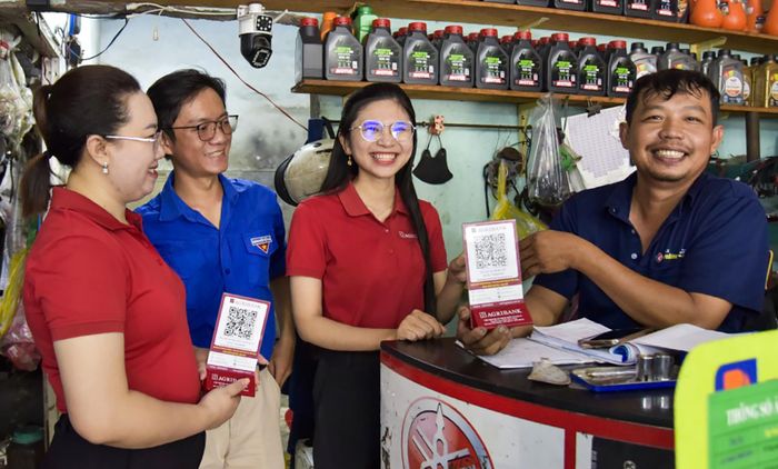 Tuổi trẻ Agribank chi nhánh An Minh Kiên Giang II ra quân hỗ trợ người dân mở tài khoản ngân hàng, cài đặt ứng dụng thanh toán điện tử, thúc đẩy thanh toán không dùng tiền mặt tại địa phương. Ảnh: ĐẶNG LINH.