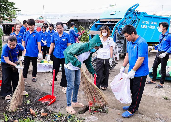 Đoàn viên, thanh niên xã Vĩnh Điều thu gom rác thải tại khuôn viên chợ Tà Êm. Ảnh: THANH NHÃ