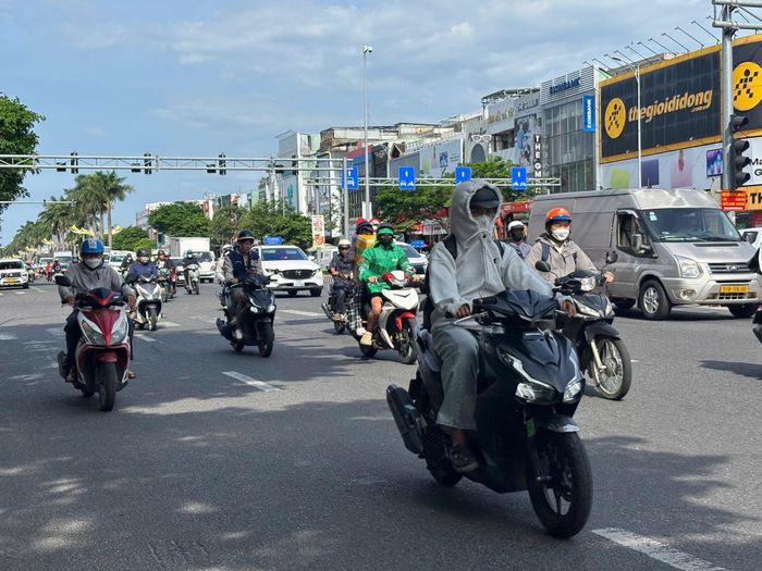 Người dân kín mít áo chống nắng ra đường. Ảnh: KHÁNH NGÂN