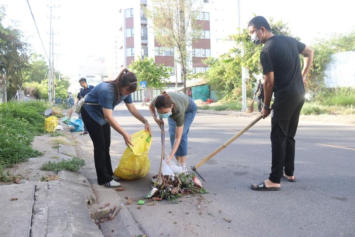 Người dân phường An Hải thu gom rác vương vãi tại các đoạn đường phía tây nam Khu công nghiệp Đà Nẵng. Ảnh: HOÀNG HIỆP