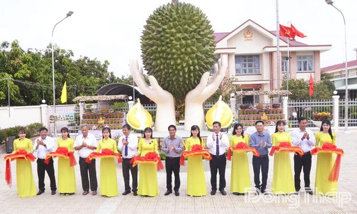 Các đại biểu thực hiện nghi thức cắt băng khánh thành biểu tượng trái sầu riêng Ngũ Hiệp.