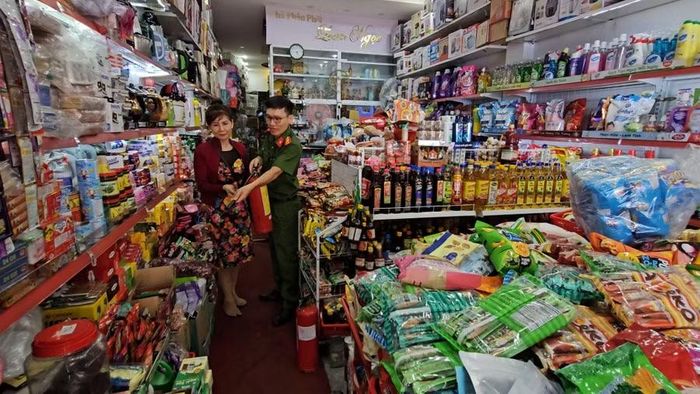 Công an cơ sở hướng dẫn chủ cơ sở kinh doanh tạp hóa cách sử dụng bình chữa cháy.