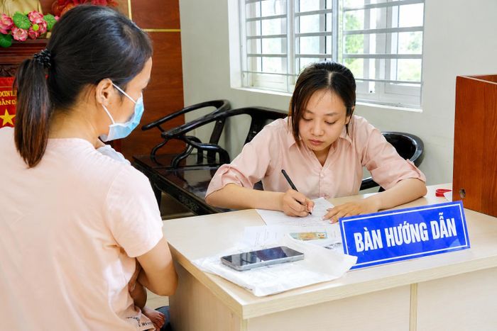 Cán bộ phường Đông Hưng Thuận hỗ trợ người dân làm thủ tục hành chính. Ảnh: Thạc Hiếu