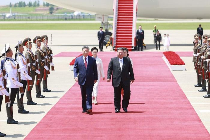 Ông Kim Jong Un và ông Tập Cận Bình cùng đi trên thảm đỏ tại sân bay. Ảnh: Tân Hoa xã