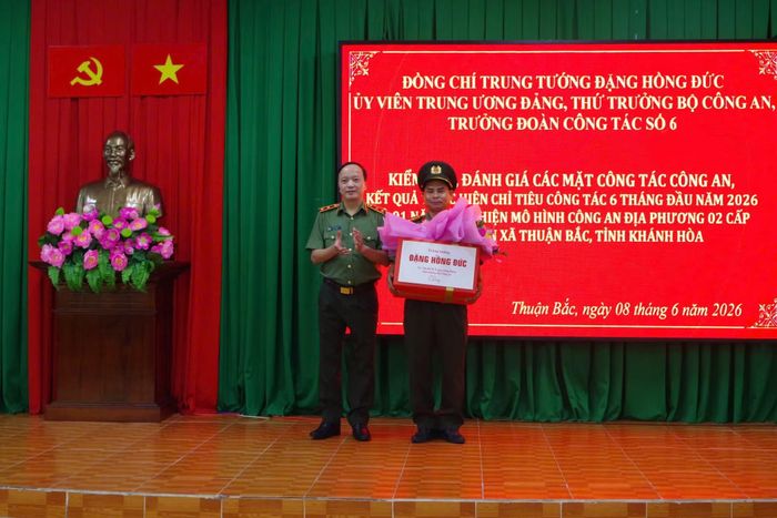 Thứ trưởng Đặng Hồng Đức tặng quà cho Đại úy Katơ Vính, cán bộ Tổ an ninh Công an xã Thuận Bắc. Ảnh: Tiến Quân.
