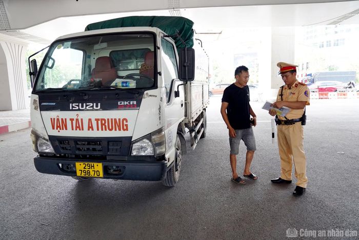  Thiếu tá Nguyễn Tuấn Điệp làm việc với một tài xế xe tải. 