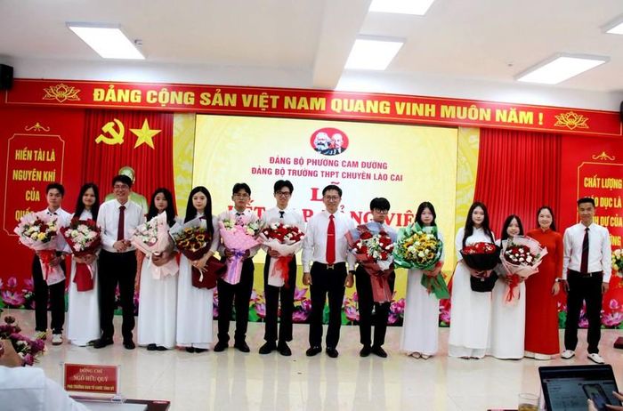 Tặng hoa chúc mừng các đảng viên mới là học sinh ưu tú Trường THPT Chuyên Lào Cai được kết nạp vào Đảng. Ảnh: CTV