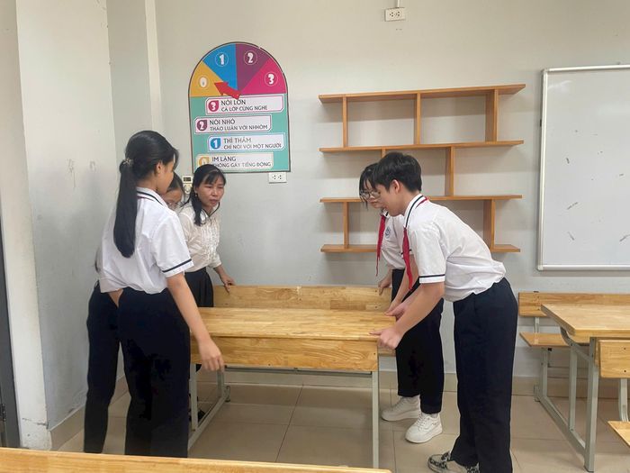 Học sinh giúp thầy cô kê lại bàn ghế trước khi kỳ thi diễn ra. Ảnh: MK