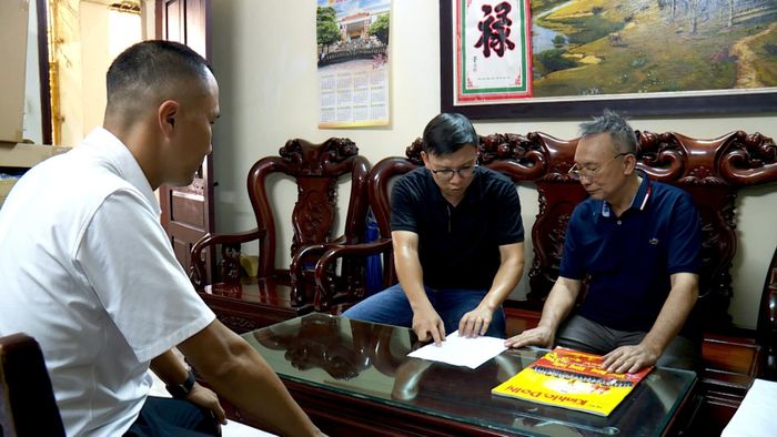 Cán bộ phường Kim Liên hướng dẫn người dân cách truy cập thông tin dự án thông qua mã QR. Ảnh: Lại Tấn