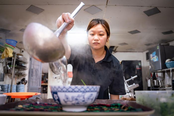 Theo Hương, công thức gia đình được giữ gần như nguyên vẹn từ năm 1925. Nước dùng không quá nặng mùi hồi, quế, thảo quả hay nước mắm như một số phong cách phở khác. Thay vào đó, quán tập trung vào vị ngọt tự nhiên từ xương và thịt sau nhiều giờ hầm liên tục. Một trong những điểm nhận diện của quán là sử dụng bánh phở bản to. Nước dùng có màu trong nhưng vị khá đậm, tạo cảm giác đậm đà khi ăn cùng bánh phở. Đây cũng là đặc trưng được duy trì từ những thế hệ đầu tiên. Trong ảnh, Hương cùng mẹ làm phở trong căn bếp của quán trên đường Nguyễn Khuyến (phường Văn Miếu Quốc Tử Giám).