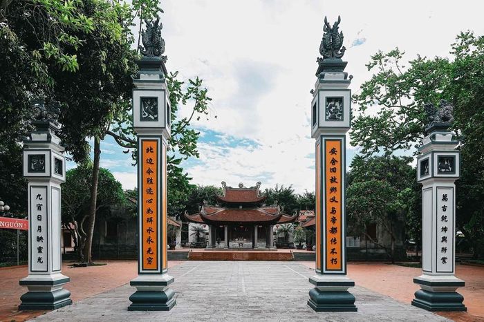 Trục thần đạo dẫn vào đình Phúc Xá, hai bên là hệ thống trụ biểu và câu đối, phía sau là mái đình cổ, nơi thờ Thái úy Việt Quốc công Lý Thường Kiệt, danh tướng Đào Kỳ, Phương Dung công chúa và các vị thành hoàng được người dân tôn kính. Ảnh: Phạm Tuấn Anh - TTXVN