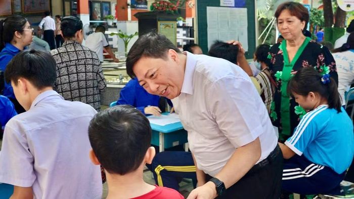 Phó Giáo sư, Tiến sĩ, bác sĩ chuyên khoa II Nguyễn Vũ Trung, Viện trưởng Viện Pasteur Thành phố Hồ Chí Minh, trò chuyện cùng người dân tại điểm tiêm phòng.