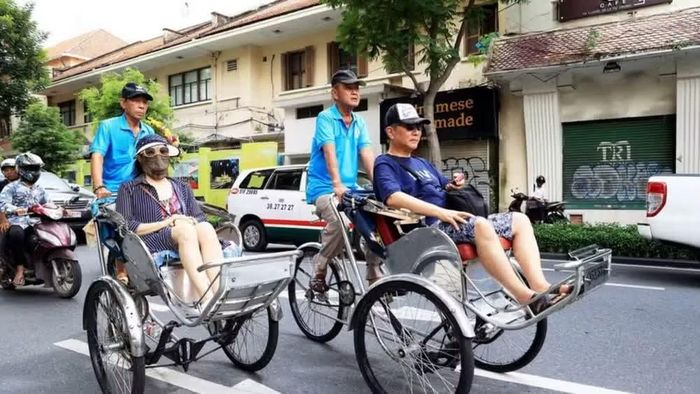 Du khách Nhật Bản khám phá trung tâm Thành phố Hồ Chí Minh bằng xích lô. (Ảnh: TTXVN)
