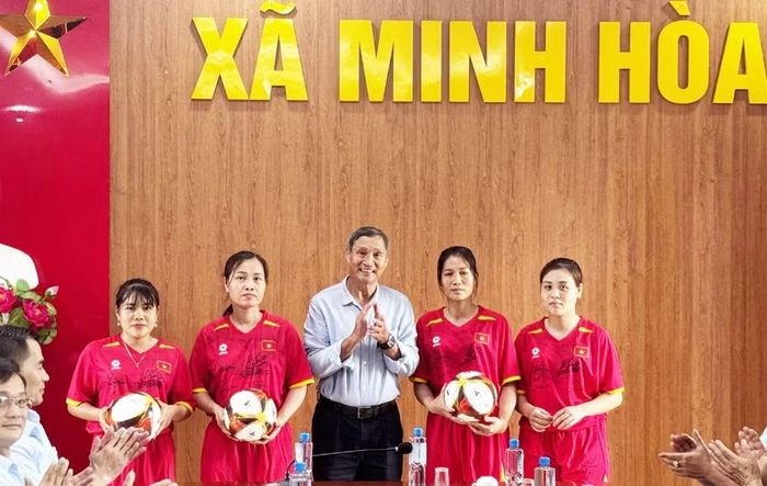 HLV Mai Đức Chung tặng bóng cho các cầu thủ nữ xã Minh Hòa.
