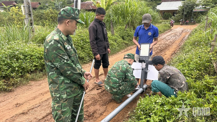 Cán bộ, chiến sĩ Đồn Biên phòng Chiềng On và nhân dân lắp đèn trong chương trình "Thắp sáng vùng biên".