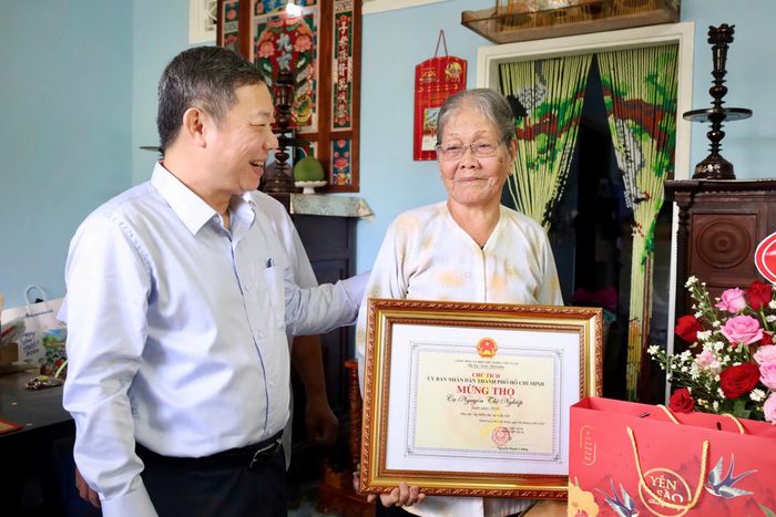 Đồng chí Dương Anh Đức trò chuyện cùng cụ Nguyễn Thị Nghiệp. Ảnh: CẨM NƯƠNG