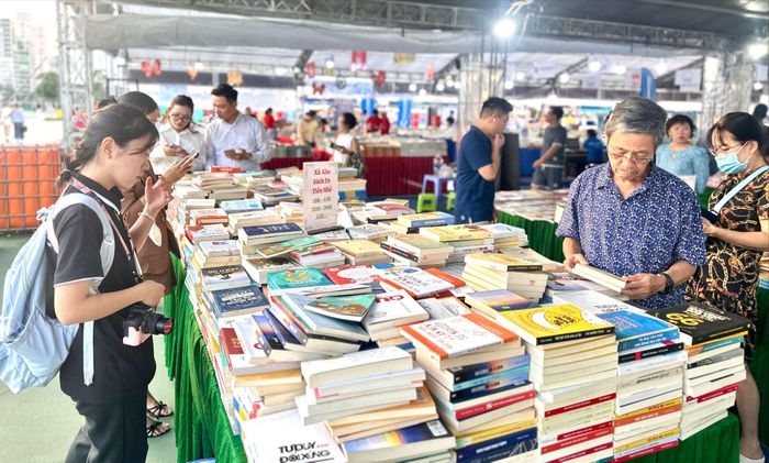 Bạn đọc tìm mua sách tại hội sách được tổ chức ở Công viên bờ sông Sài Gòn. Ảnh HUY SƠN