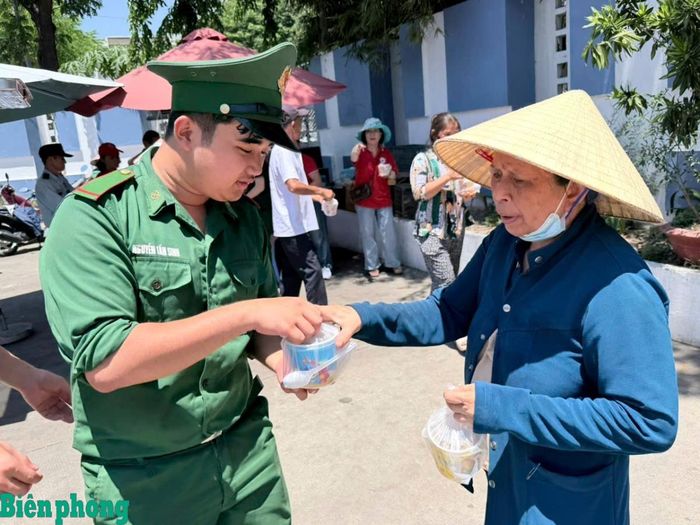 Hạ sĩ Nguyễn Tấn Sinh phát cơm cho người nhà bệnh nhân đang điều trị tại Bệnh viện Ung bướu thành phố Đà Nẵng. Ảnh: Trúc Hà
