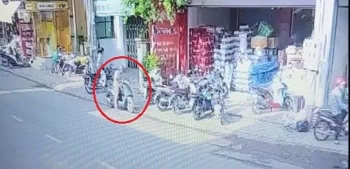 Người đàn ông đi xe máy tới, xách trên tay vật nghi là can xăng rồi đi vào cửa hàng tưới lên hàng hóa. Ảnh cắt từ clip