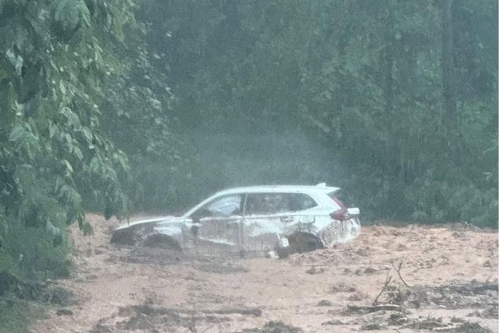 Chiếc xe chở hai vợ chồng và cháu nhỏ bị đất, đá vùi lấp nửa thân xe, may mắn không bị thiệt hại về người