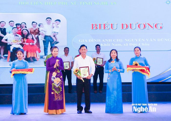 Các đồng chí: Võ Thị Minh Sinh - Phó Bí thư Tỉnh ủy, Chủ tịch Ủy ban MTTQ Việt Nam tỉnh; Hoàng Thị Thu Hiền - Phó Chủ tịch Ủy ban MTTQ Việt Nam tỉnh, Chủ tịch Hội Liên hiệp Phụ nữ tỉnh trao biểu trưng cho gia đình tiêu biểu. Ảnh: Mai Hoa