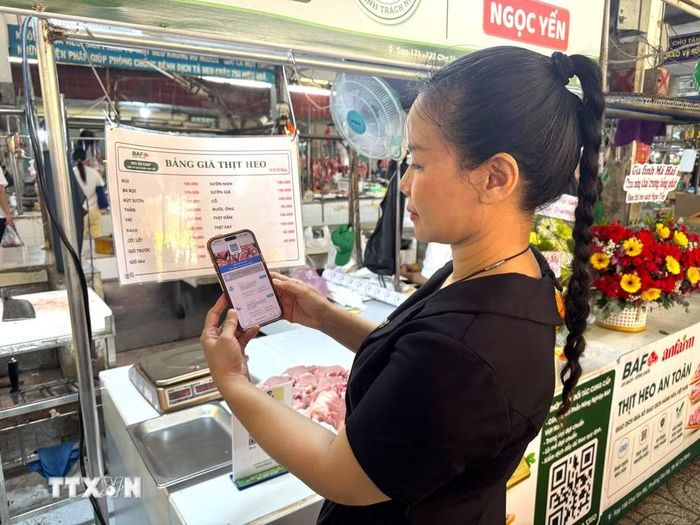 Người dân Thành phố Hồ Chí Minh quét mã để truy xuất thông tin về sản phẩm thịt lợn, từ trang trại đến quá trình vận chuyển, giết mổ. (Ảnh: Hương Giang/TTXVN)