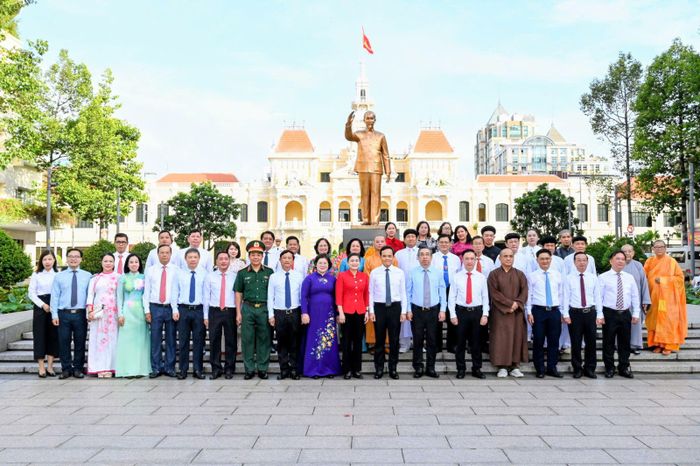 Các đại biểu TP Hồ Chí Minh chụp ảnh kỉ niệm tại khu vực tượng đài Bác Hồ trên phố đi bộ Nguyễn Huệ.