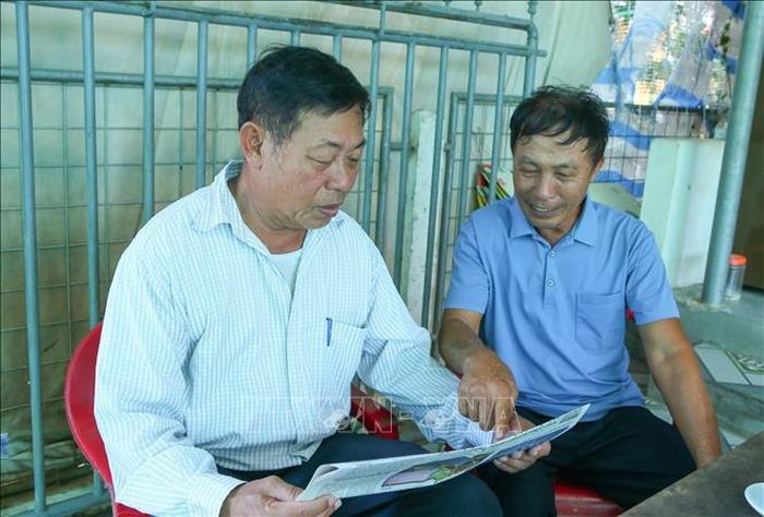 Cựu chiến binh Đỗ Đình Giao (phải) thường xuyên đọc báo để cập nhật thông tin.