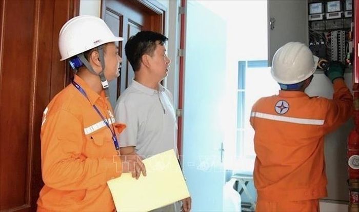 Công nhân EVNHANOI tuyên truyền phòng chống chấy nổ và kiểm tra an toàn điện tại hộ dân.