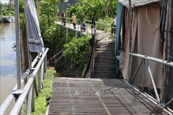 Vụ sạt lở làm hư hỏng hoàn toàn cây cầu gỗ dân sinh dài khoảng 15 mét, ảnh hưởng đến việc đi lại của người dân địa phương. Ảnh: TTXVN phát
