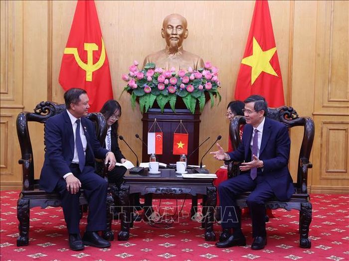 Đồng chí Đoàn Minh Huấn, Ủy viên Bộ Chính trị, Giám đốc Học viện Chính trị quốc gia Hồ Chí Minh tiếp ông Lee Hong Chuang, Trưởng Nghị sĩ Quốc hội Singapore, Trưởng Nhóm Nghị sĩ Quốc hội khu vực Jurong East-Bukit Batok GRC. Ảnh: Văn Điệp/TTXVN.