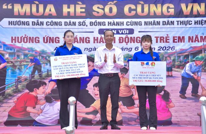 Đại diện Trường Đại học Văn hóa TP. Hồ Chí Minh và Trường Đại học Y khoa Phạm Ngọc Thạch trao bảng tượng trưng kinh phí tặng quà cho nạn nhân chất độc da cam, học sinh có hoàn cảnh khó khăn, tài trợ công trình tuyến đường cờ Tổ quốc, thắp sáng đường quê, tặng quà cựu thanh niên xung phong trên địa bàn xã.