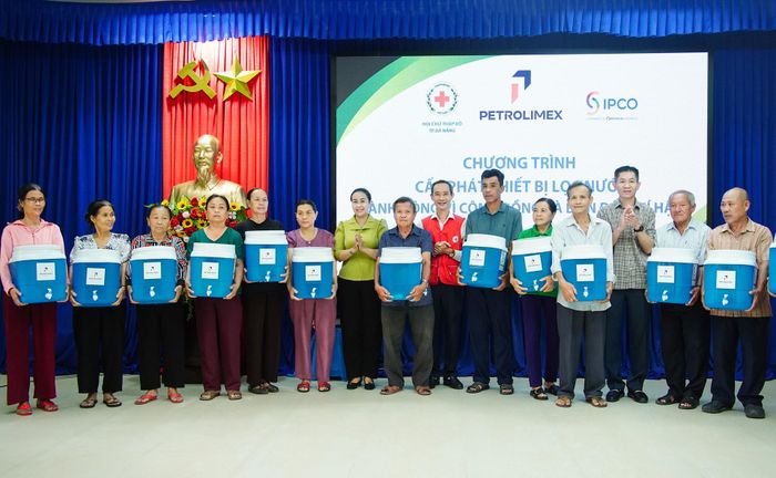 Phó Chủ tịch UBND thành phố Nguyễn Thị Anh Thi (thứ 7, bên trái sang) trao máy lọc nước cho người dân xã Tân Hiệp. Ảnh: VĂN HÙNG - HOÀN VŨ