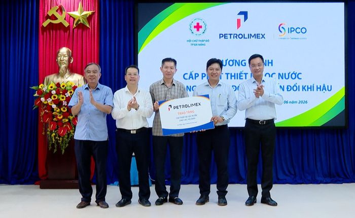 Lãnh đạo xã Tân Hiệp (thứ 2, phải sang) nhận hỗ trợ máy lọc nước từ Tập đoàn Xăng dầu Việt Nam. Ảnh: VĂN HÙNG - HOÀN VŨ
