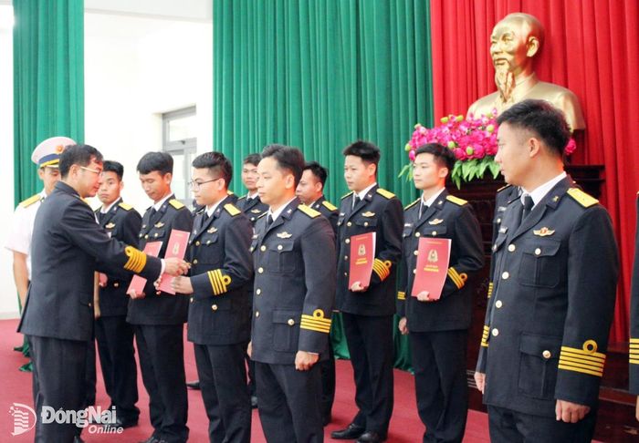 Đại tá Nguyễn Hữu Lương trao quyết định thăng quân hàm cho các cán bộ. Ảnh: ĐVCC