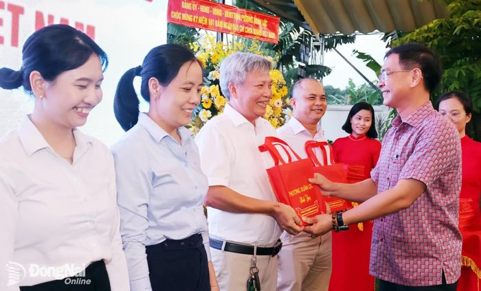 Phó Bí thư Đảng ủy, Chủ tịch UBND phường Xuân Lộc Lê Khắc Sơn tặng quà chúc mừng các nhà báo. Ảnh: Nguyệt Hà
