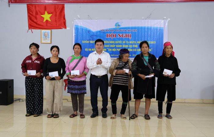 Đồng chí Lò Văn Học - Phó Bí thư Thường trực Đảng ủy xã tặng quà cho hội viên phụ nữ có hoàn thành khó khăn.