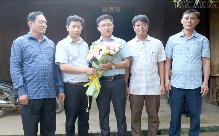 Lãnh đạo xã Chế Tạo tặng hoa cháu Giàng A Chanh (giữa ảnh) đang học Tiến sĩ ngành Quản lý công.