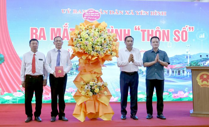 Các đồng chí lãnh đạo tỉnh tặng hoa chúc mừng thôn 6, thôn đầu tiên của xã Yên Bình hoàn thành 21/21 tiêu chí thôn số.