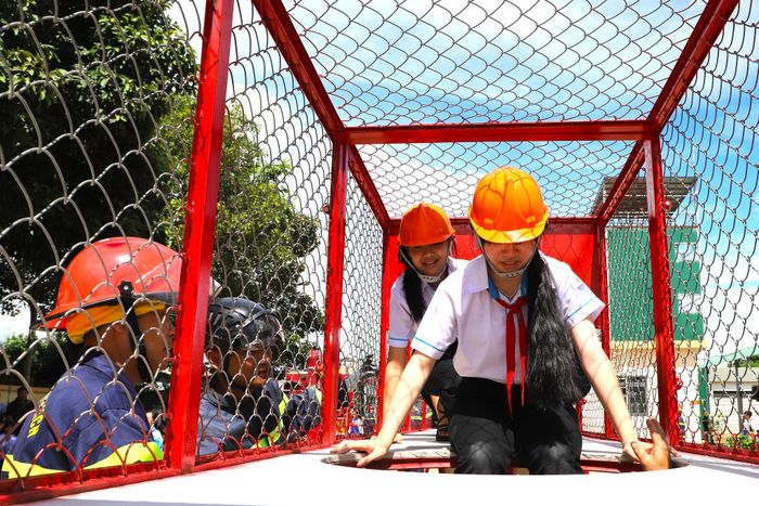 Các em học sinh hào hứng trải nghiệm khu vực di chuyển thoát nạn trong không gian hạn chế