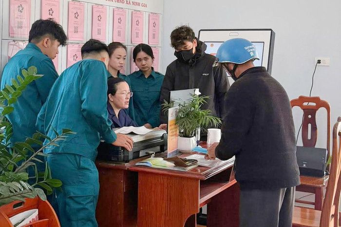 Lực lượng dân quân tự vệ tham gia hỗ trợ người dân làm thủ tục tại TTPVHCC của xã