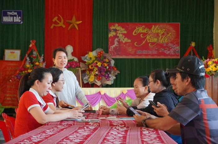 Người dân đến nhà văn hóa thôn để được hỗ trợ xác thực thông tin thuê bao - Ảnh: H.L