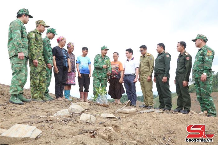 Cán bộ, chiến sĩ Đồn Biên phòng Chiềng Tương hướng dẫn nhân dân bản Móng Nặm, huyện Xiềng Khọ, tỉnh Hủa Phăn, nước CHDCND Lào kỹ thuật trồng, chăm sóc cây cà phê.