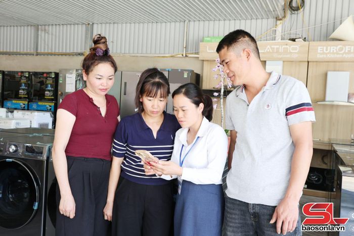 Cán bộ Trung tâm Phục vụ hành chính công xã Mường Chanh hướng dẫn nhân dân bản Mé sử dụng dịch vụ hành chính công trên điện thoại thông minh.
