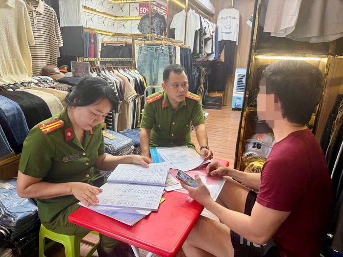 Cơ quan Công an kiểm tra làm việc với chủ một cửa hàng kinh doanh thời trang quần áo.
