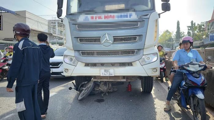 Xe máy và nạn nhân bị cuốn vào gầm xe trộn bê tông.