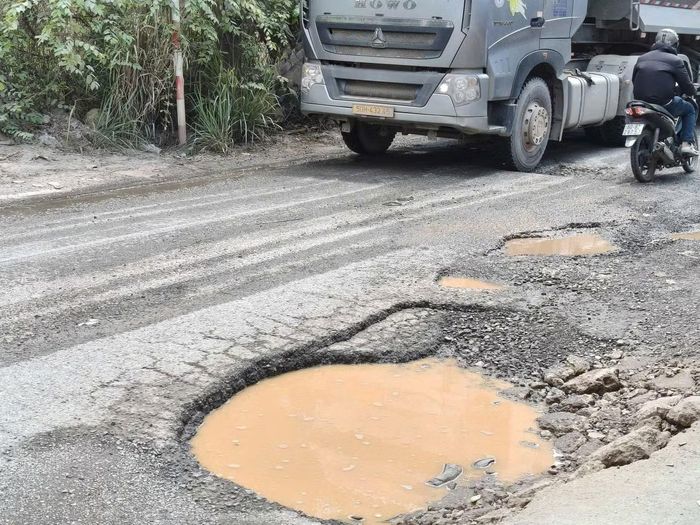 Mặt đường, nơi các phương tiện chở vật liệu phục vụ công trình trọng điểm xuất hiện nhiều ổ gà, ổ voi khiến việc đi lại của người dân gặp nhiều khó khăn, nguy hiểm.