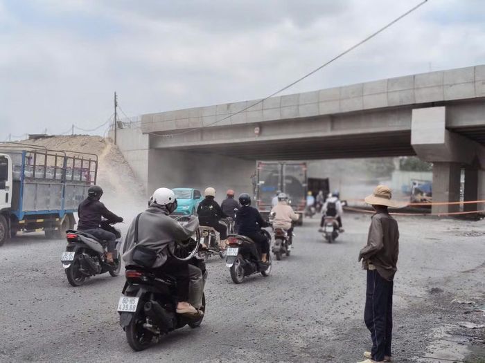 Người dân vất vả đi qua những làn bụi khi có phương tiện giao thông lớn đi qua.